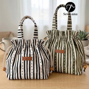 Peut inclure: Deux sacs fourre-tout à cordon de serrage. L'un est à rayures noires et blanches, l'autre à rayures vert olive et blanches. Les deux sacs ont une petite poche et une étiquette "handmade". Les sacs ont une fermeture à cordon et des perles en bois.