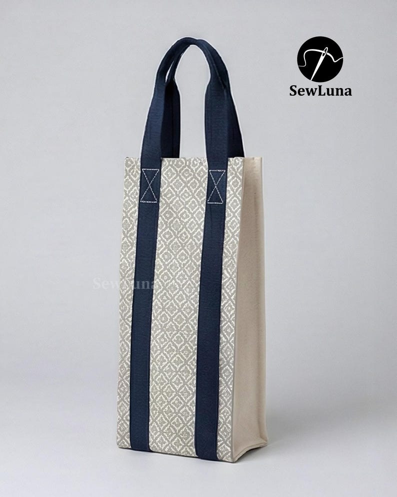 Tall fabric wine bottle carrier with a grey geometric pattern and navy straps, standing on a wooden table next to a wine bottle tied with a red ribbon. Modern kitchen background. Represents a digital sewing pattern for a reusable wine tote bag.