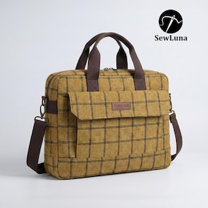 Mustard yellow plaid handmade laptop bag sewing pattern featuring brown webbing handles, an adjustable shoulder strap, a top zipper, and a front flap pocket, displayed on a clean white background.