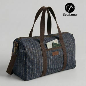 Op de afbeelding: Een blauw-bruine duffeltas met verticale strepen. De tas heeft bruine handvatten, een schouderriem en een voorvak. De tas bevat een paspoort en een kaart. De tas heeft de tekst "SewLuna".