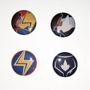 May include: Eight circular badges with comic book character designs. The badges feature red, blue, yellow, and white colours. Some badges have text that reads "Avenger" and "Higher Further Faster".