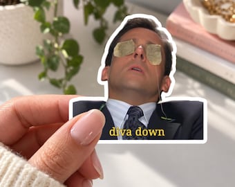 Könnte beinhalten: Ein gestanzter Vinyl-Aufkleber, der einen Mann in einem dunklen Anzug, einem hellblauen Hemd und einer gemusterten Krawatte mit Teebeuteln auf den Augen zeigt. Der Text "diva down" ist in gelben Buchstaben unten auf dem Anzug aufgedruckt.