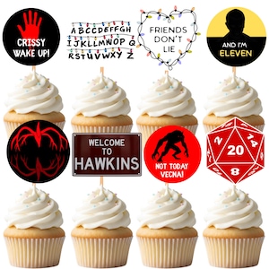 May include: Cupcakes with white frosting and themed toppers. Toppers include the text "Crissy Wake Up!", a string of lights with letters, "Friends Don't Lie", and "And I'm Eleven". Other toppers feature a red hand, a monster, and a red die.