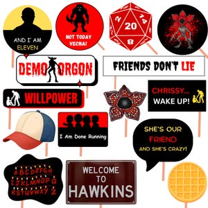 May include: A collection of themed photo booth props featuring text and graphics. Includes signs with phrases like "Friends Don't Lie" and "Welcome to Hawkins", along with a baseball cap and a waffle.