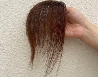 Flequillo castaño oscuro con pinzas y patillas