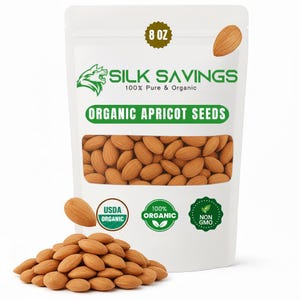 May include: A white bag of Silk Savings organic apricot seeds, 8 oz. The bag has a clear window showing the seeds. A pile of seeds is in front of the bag. The bag also has the USDA Organic and Non-GMO labels.