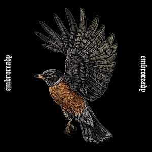 May include: A detailed embroidery design of a robin in flight with wings spread wide, featuring orange, brown, and white thread on a black background. The text "embroready" is stitched in a gothic font on both the left and right sides of the bird.