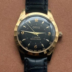 Vintage Oris handuppdragen klocka: svart urtavla, guldfärgad boett, tillverkad i Schweiz