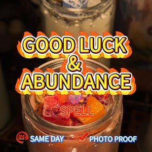 May include: A glass jar candle with the words "GOOD LUCK & ABUNDANCE SPELL" in a flame-like font. The candle has a pinkish hue and contains colorful crystals and dried flowers. The image also includes text that says "SAME DAY PHOTO PROOF".