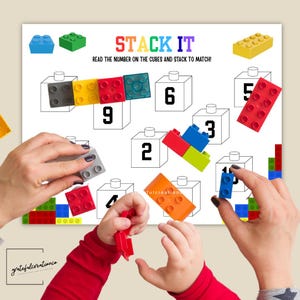 May include: A colorful educational game with the text "STACK IT" and instructions. The game features numbered cubes and various colored building blocks. Hands are shown stacking the blocks to match the numbers.