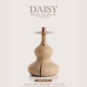 May include: A light-colored wooden candlestick with a bulbous, organic shape and a copper-colored metal top. The base features a vertical crack in the wood. Text on the image includes DAISY Wooden Candlesticks, DAISY ŞA 24113, and dimensions: 19cm height, 15cm base diameter, 2cm top diameter.