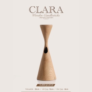 May include: A light-colored wooden candlestick labeled CLARA Wooden Candlesticks. The object features a tapered hourglass shape with a hollow cutout in the center. It stands 35 cm tall, with a 13 cm base diameter and an 8 cm top diameter.