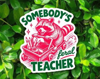 May include: A die-cut sticker featuring a red and white illustration of a raccoon riding in a red wagon filled with pencils, a book, and an apple. The text reads SOMEBODY'S feral TEACHER in bold green letters, accented by small star shapes.