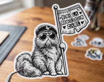 Op de afbeelding: Een zwart-witte sticker van een pluizige kat met een zonnebril en een baret met een dinosaurus-embleem. De kat houdt een vlag vast met de tekst VIVA LA REVOLUCION CARL, omringd door kleine hartjes. Het ontwerp is gedetailleerd met inktlijnen.