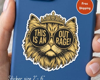 May include: A die-cut sticker featuring a golden-furred cat wearing a crown and black circular sunglasses. The text on the lenses reads THIS IS AN OUT RAGE!. The sticker is applied to a blue phone case. The sticker size is listed as 2"- 6".