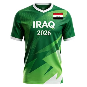 May include: Green and white soccer jersey with the word "IRAQ" in large white letters and the year "2026" below. The Iraqi flag is on the upper right chest. The jersey has a V-neck and white trim.