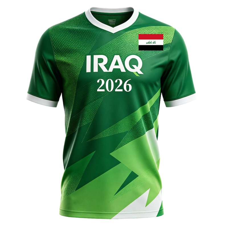 May include: Green and white soccer jersey with the word "IRAQ" in large white letters and the year "2026" below. The Iraqi flag is on the upper right chest. The jersey has a V-neck and white trim.