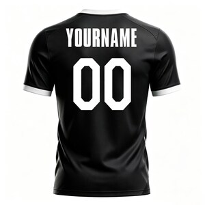 May include: Black athletic jersey with white trim on the collar and sleeves. The back of the jersey displays the name "YOURNAME" above the number "00" in white, block lettering. The jersey is a solid black color.