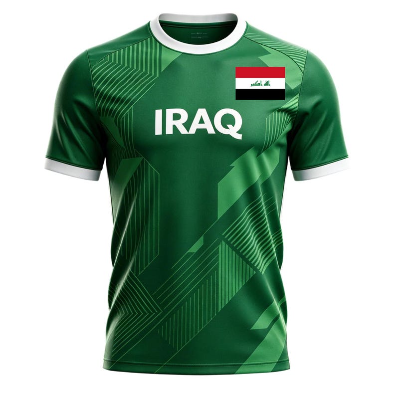 May include: Green athletic jersey with white trim and the word "IRAQ" in large white letters. The jersey features a geometric design and the Iraqi flag on the upper right chest. The shirt has short sleeves and a crew neck.