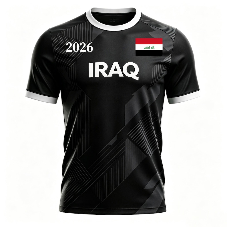 May include: Black soccer jersey with white trim and the word "IRAQ" in large white letters. The number "2026" is above the word "IRAQ". The Iraqi flag is on the right chest.