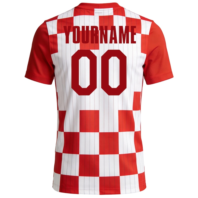 May include: A red and white chequered football shirt with red sleeves. The back displays the text "YOURNAME" above the number "00" in red. The shirt has a traditional athletic design.