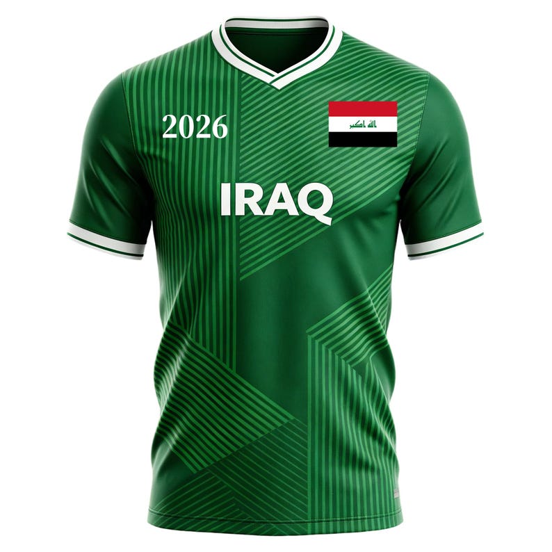 May include: Green soccer jersey with white trim and a V-neck collar. The jersey features the word "IRAQ" in white block letters, the number "2026", and the Iraqi flag on the right chest. The shirt has a striped design.