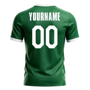 May include: Green athletic jersey with white trim on the collar and sleeves. The back of the jersey displays the word "YOURNAME" above the number "00" in white block letters. The jersey is made of a smooth, athletic fabric.