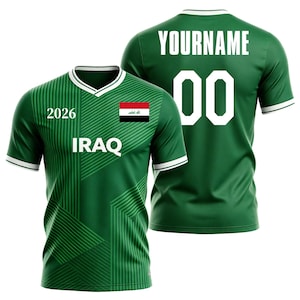 Puede incluir: Camiseta de fútbol verde con detalles blancos, con las palabras "2026" e "IRAQ" en la parte delantera, junto con la bandera iraquí. La parte trasera muestra "YOURNAME" y el número "00" en blanco.