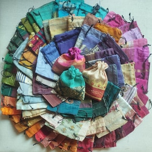 May include: A collection of colourful fabric drawstring pouches with various patterns and designs. The pouches are made of silk and are ideal for storing small items.