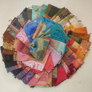 May include: A collection of colorful fabric drawstring bags arranged in a circle. The bags are made from a variety of fabrics, including silk, cotton, and linen. They are all different sizes and shapes, and some have intricate patterns.