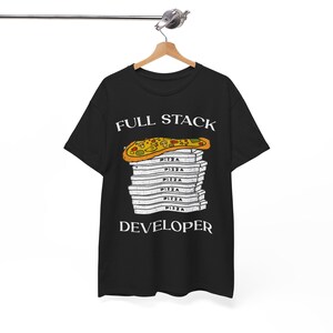 Op de afbeelding: Zwart T-shirt met de witte tekst "FULL STACK DEVELOPER". De afbeelding toont een pizzapunt bovenop een stapel pizzadozen, elk met het woord "PIZZA" erop.