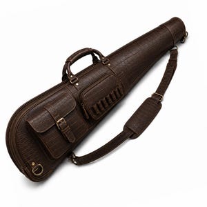 May include: A dark brown, crocodile-textured carrying case with a tapered shape. It features a top handle, an adjustable shoulder strap with a padded section, a front pocket with a buckle closure, and a smaller zippered pocket with external loops.