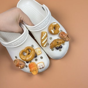 May include: A set of three ceramic mugs with a speckled, matte finish. The mugs are in shades of cream, light gray, and dark gray. Each mug has a simple, minimalist design and a rounded handle. Perfect for coffee or tea.