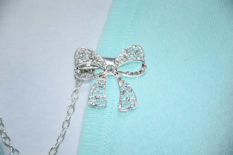 Single or double silver chain Sweater clips Large rhinestone bow Cardigan clasp