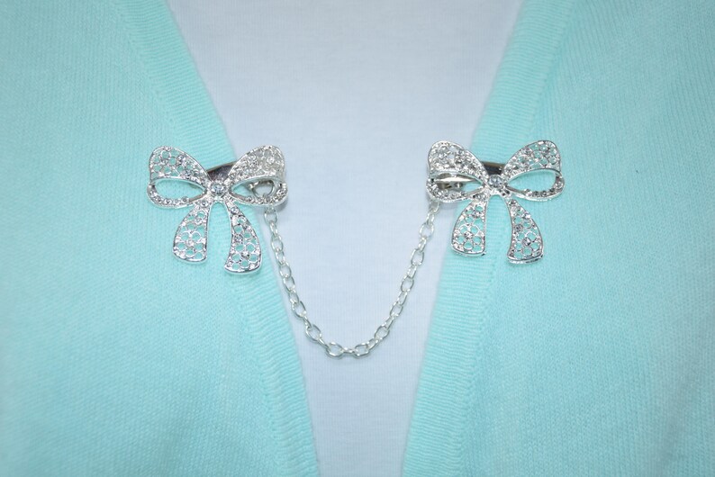 Single or double silver chain Sweater clips Large rhinestone bow Cardigan clasp