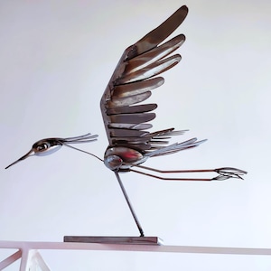 Sculpture de héron en vol réalisée avec d'anciens couverts en acier inoxydable