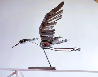 Sculpture of a heron in flight made with old stainless steel cutlery