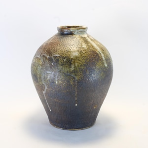 May include: A handcrafted ceramic vase with a textured surface. The vase features a dark brown base that transitions to olive green and lighter brown hues near the top. White drips cascade down the sides, adding a unique visual element.