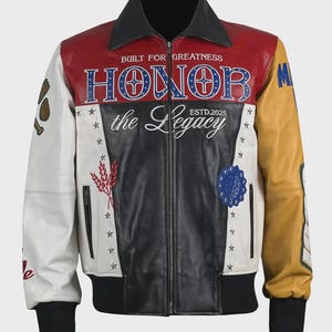 Puede incluir: Chaqueta de cuero multicolor con cuello y puños negros. La chaqueta presenta paneles rojos, blancos, negros y amarillos con parches bordados y el texto "BUILT FOR GREATNESS" y "HONOR the Legacy ESTD.2025".