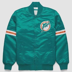 Könnte beinhalten: Türkisfarbene Satin-Bomberjacke mit weißen und orangefarbenen Streifen auf den Ärmeln. Mit einem Teamlogo-Patch auf der Brust. Die Jacke hat einen gerippten Kragen, Bündchen und Saum.
