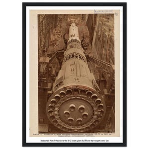 Könnte beinhalten: Ein Sepia-Foto einer Rakete während der Montage. Die Rakete ist zylindrisch mit mehreren Abschnitten und einer kreisförmigen Basis. Der Text in Russisch und Englisch beschreibt die Platzierung des Raketensystems auf einer Transport- und Aufbaueinheit.