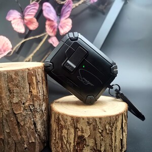 May include: Black protective case with the word "Sawyer" in a script font. The case has a rugged design with a hinged lid and a small key ring attachment. The word "OPEN" is visible on the case.