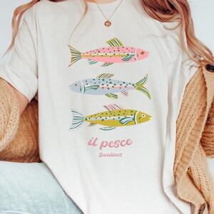 Comfort colors cream t-shirt with colorful sardine graphic
Italian summer vacation shirt for women
Il pesce fish illustration tee
European holiday coastal aesthetic top