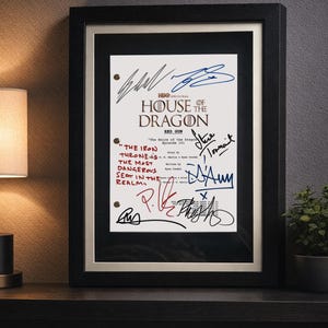 Peut inclure: Une page de script encadrée de House of the Dragon intitulée Red Gun, épisode 101. Le papier blanc présente du texte noir, le logo de la série et des notes manuscrites à l'encre rouge lisant The Iron Throne is the most dangerous seat in the realm.