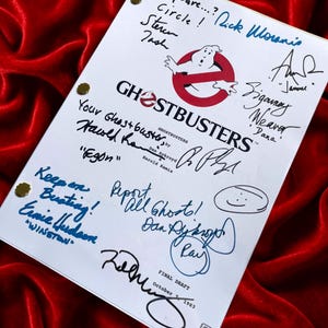 Puede incluir: Un guion blanco de Ghostbusters con el logo de Ghostbusters y firmas. El guion se titula "FINAL DRAFT" y está fechado el 7 de octubre de 1983. Sobre un fondo de terciopelo rojo.