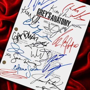 Può includere: Una sceneggiatura bianca con il titolo "Grey's Anatomy" e numerose firme in inchiostro blu, rosso e nero. La sceneggiatura è su uno sfondo di velluto rosso. Il titolo dell'episodio "A Hard Day's Night" è visibile.