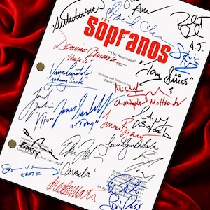 May include: A white sheet of paper featuring numerous signatures and the title "The Sopranos" in red. The signatures are in diverse colours, including blue and black, set against a red velvet backdrop.