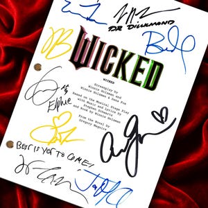 May include: A white screenplay cover for the film Wicked, featuring the title in green and black lettering. The page includes credits for Winnie Holzman, Dana Fox, Stephen Schwartz, and Gregory Maguire, along with multiple colourful ink signatures.