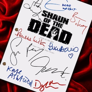 Op de afbeelding: Een wit papier met de titel "SHAUN OF THE DEAD" in zwart, met meerdere handtekeningen in blauwe, zwarte en rode inkt. Het papier heeft drie perforaties en ligt op een rode fluwelen achtergrond.
