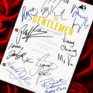 Pode incluir: Um roteiro de filmagem branco para a série de televisão The Gentlemen, com os logotipos da Miramax e Netflix, episódio 101, escrito por Guy Ritchie e Matthew Read, e coberto com múltiplas assinaturas em tinta preta e azul do elenco e equipe.